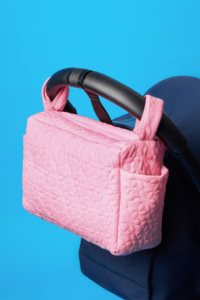 pochette organisateur poussette en nylon. Broderie matelassée ton sur ton. Deux poches sur le côté pour le biberon. Sac avec attache pour mettre sur la poussette pour les balades avec bébés.Sur la photo, la pochette est installée sur une poussette yoyo. Fermeture par un zip ton sur ton. 26 PARADIS